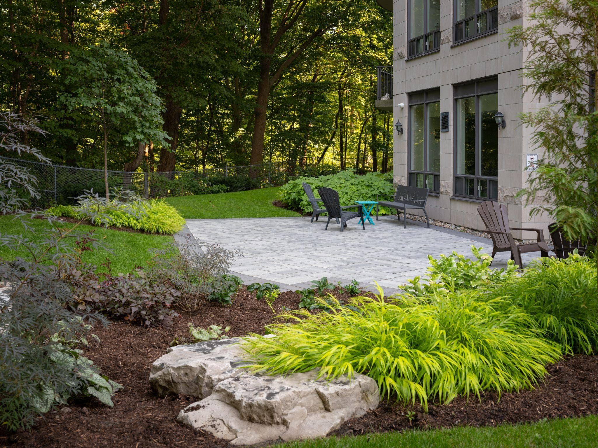 Finished paver patio surrounded by landscaped planting beds